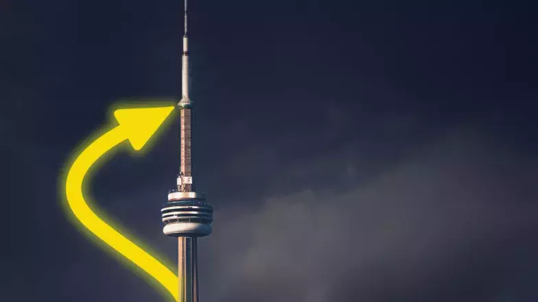 Atop the CN Tower, a vibrant yellow arrow directs its gaze skyward on a night sky.