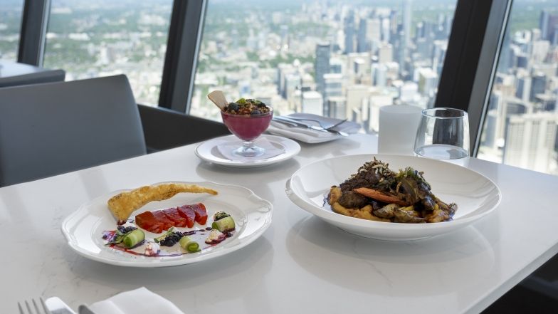 The entire Indigenous menu on a table at 360 overlooking the view of the city of Toronto.