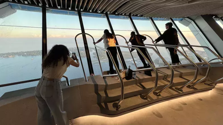 Three guests enjoy the OverView experience, one person is on the left taking a picture.