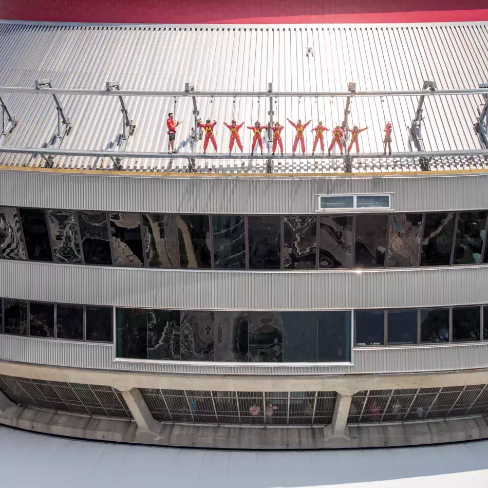 Group of people leaning over the edge walk as viewed from the eye level.